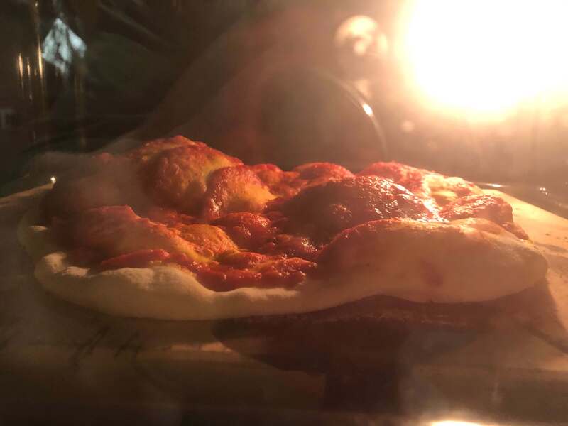 Masa de pizza en el horno en plena cocción