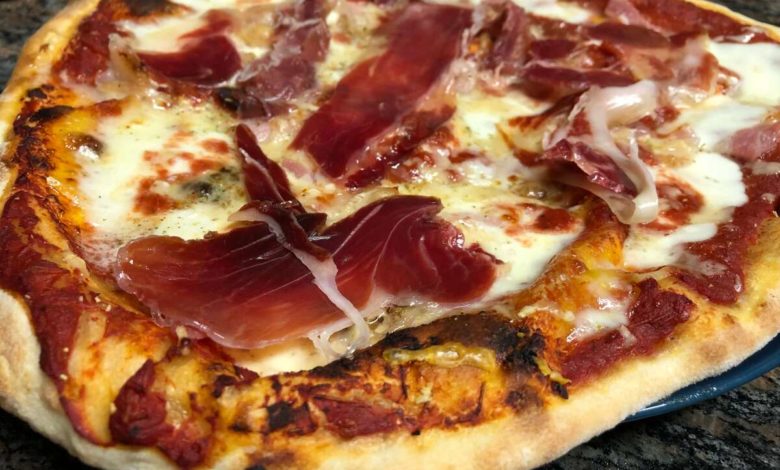 Presentación de una pizza con jamon y queso casera